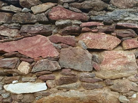 A close-up view of a rustic stone wall of an old barn Stock Photos