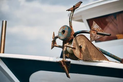 Close up view of a rusty old metal anchor mounted on a boat deck Stock Photos