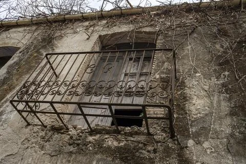 Close up view of rusty wrought iron balcony attached to stone wall with dec.. Stock Photos
