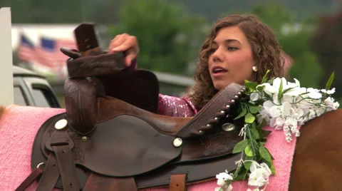 Close view of saddle decorated with flowers and face of young woman preparing to Stock Footage 59533283