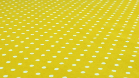 Close-up view of the safety yellow with white polka dots cotton fabric rotated  Stock Footage 293884737