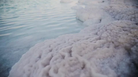 Close up view of salt that is in the Dead Sea. Steadicam walking shot Vídeo Stock 273914509