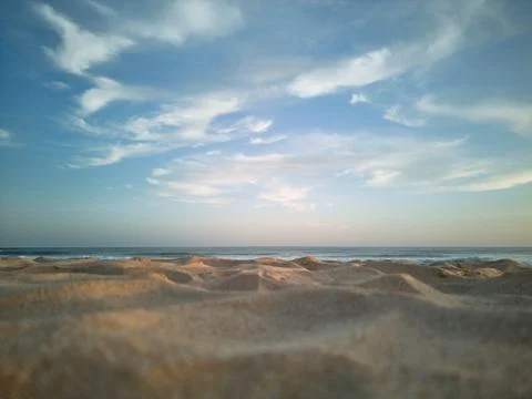 Close-up view of the sand on the beach with ocean and cirrus clouds Foto stock