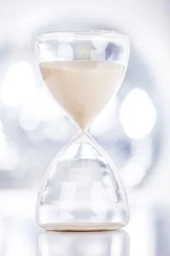 Close view of sand flowing through an hourglass Foto stock