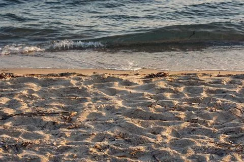 Close-up view of sandy beach with gentle waves washing ashore in Greece Stock Photos