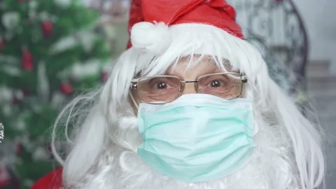 Close view of santa claus in red cap and protective face mask at home Stock Footage 144385318