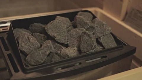Close up view of a sauna heater with hot stones inside a wooden finnish bath for Vídeos de archivo 334308779