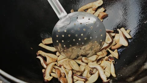 Close up view of sauteed slices of Common Mushrooms cooking in the pan WOK. Stock Footage 205884067