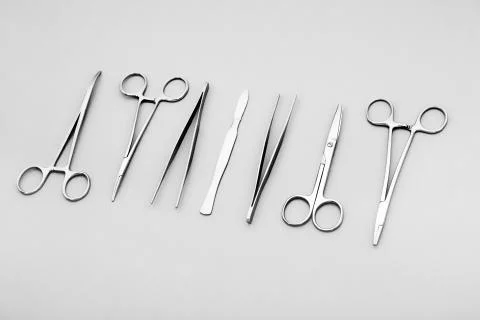Close-up view on scalpel, scissors, forceps and clamps on grey background Stock Photos