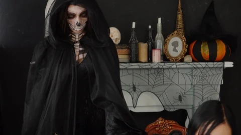 Close up view on scary spooky Skeleton Death Reaper staring directly at pretty Stock Footage 96210124