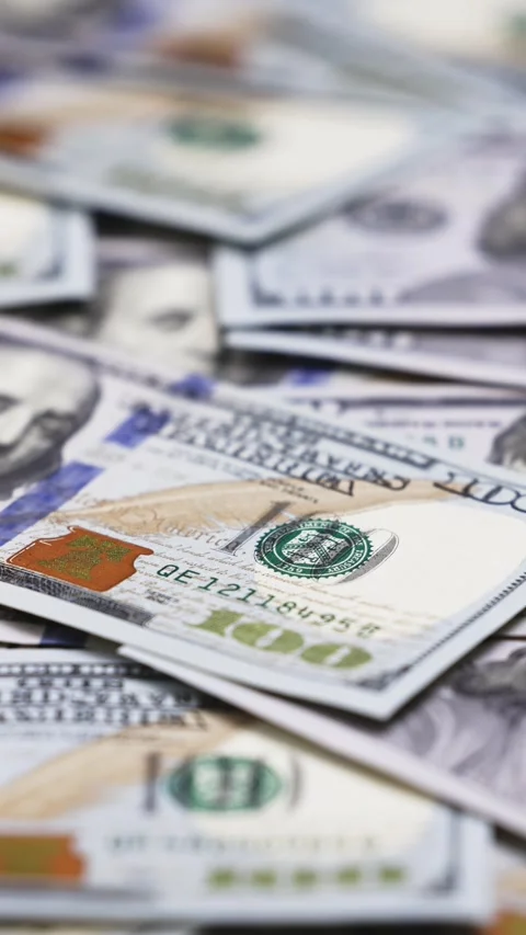 Close-up view of scattered hundred-dollar bills displaying intricate details of 스톡 동영상 328124729