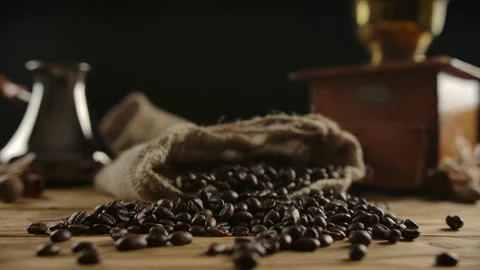 Close up view of scattered roasted dark coffee beans from jute sack. Traditional Stock Footage 140364981