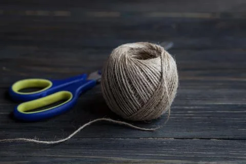 Close-up view of scissors and twine on wooden background Stock Photos
