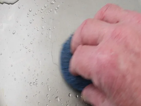 Close view of scrubbing a stainless steel pan Stock Footage