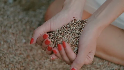 Close up view of sea sand running through female hands with red nails Stock Footage 86677278