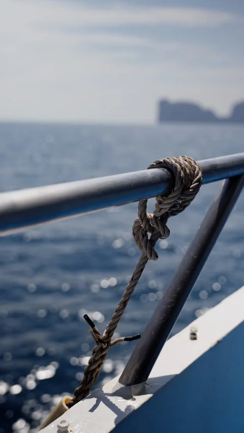 Close-up view of a securely tied rope around a metal railing on a boat, with Stock Footage 310490837