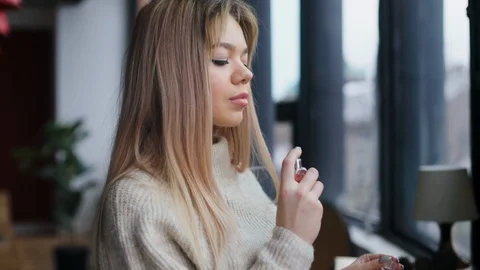 Close up view of seductive blonde young Caucasian woman spraying perfume on Video stock 104564768
