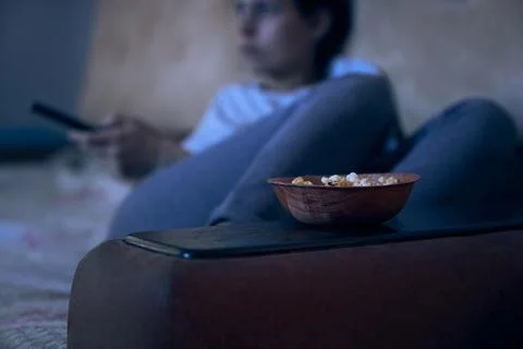 Close up view of selective focus on plate with popcorn with blurred woman Fotos de archivo