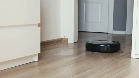 Close-up view on a self-moving robotic vacuum on the floor. Stock Footage 130429259