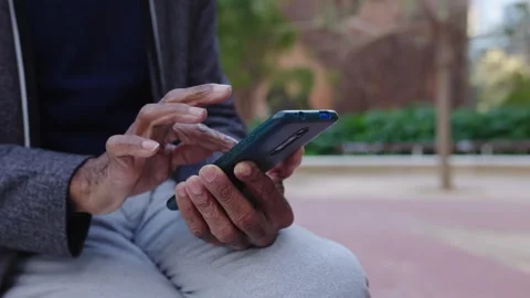 Close up view of senior man using mobile phone while sitting at city street.  Stock Footage 289926359
