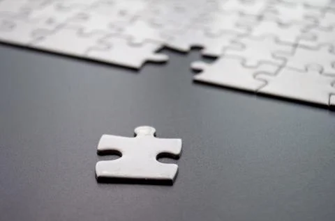 Close up view of separated jigsaw on dark cover background Foto stock