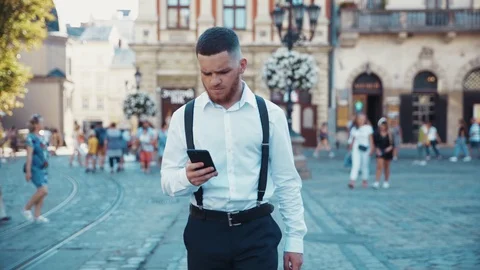 Close up view of serious stylish bearded businessman walking down the crowded Stock Footage 115666968