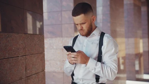 Close up view of serious young man in formal outfit outdoors actively using Stock Footage 115667063