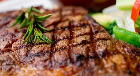 Close up view on serving of marinated grilled rib eye steak with baked potato Photos