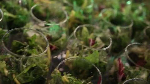 Close-up view on set of glasses with salad on high legs with blur bokeh lights. Stockbeeldmateriaal 72603220