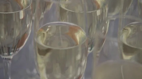 Close-up view on set of transparent glasses with white wine. Slow motion. Video stock 72603255