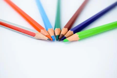 Close-up view of seven different colored pencils arranged in a half circle pa Stock Photos