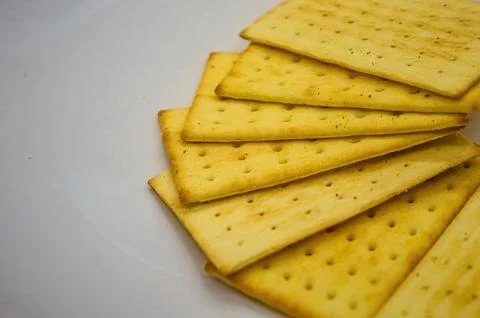 A close up view of several golden, rectangular crackers fanned out on a bri.. Foto stock