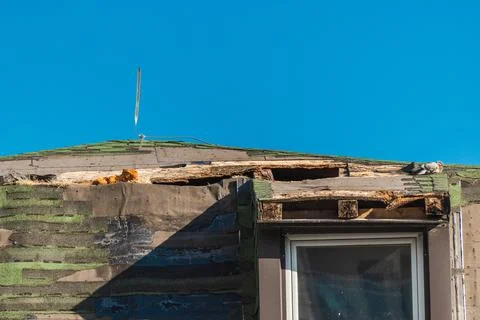 Close View of a Severely Damaged Flat Roof Above a Window Stock Photos
