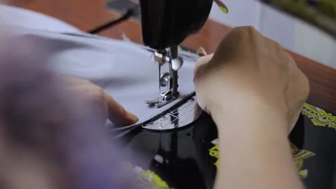 Close up view of sewing process. Female hands stitching grey textile fabric.. Stock Footage 269158505
