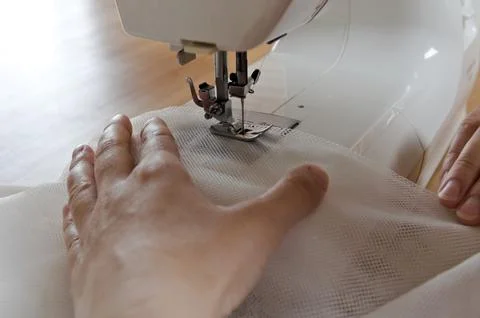 Close up view of sewing process. Female hands stritching white fabric Foto stock