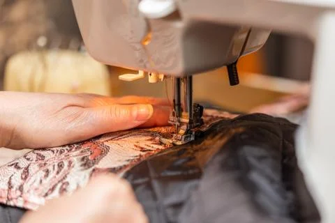 A close-up view of sewing process, hand of old woman using sewing machine Stock Photos