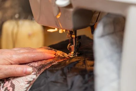 A close-up view of sewing process, hand of old woman using sewing machine Stock Photos