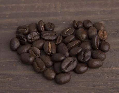 Close view of shape of heart made of coffee beans on the wood 스톡 사진