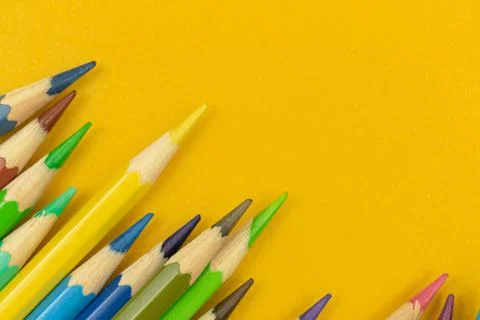 Close-up view to sharp color pencils on a yellow table backgroun, copy space, Stockfoto's