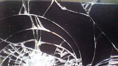 Close up view of a shattered black smartphone glass screen Stock Photos
