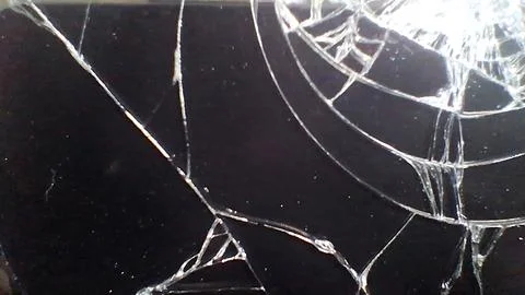 Close up view of a shattered black smartphone glass screen display Foto stock