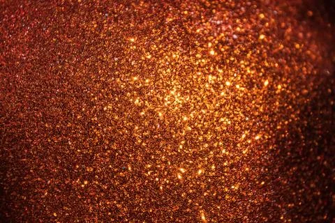 A close-up view of a shimmering orange surface, densely packed with fine gl.. 스톡 사진
