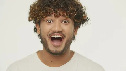 Close-up view of shocked mixed man enjoying good news. Front view of handsome Stock Footage 231475951