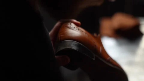 Close-up view of shoemaker wearing black gloves painting heel and sole of light Video stock 150010902