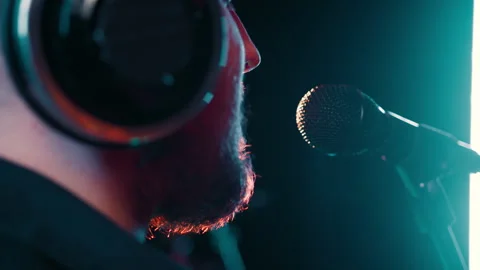Close up view from shoulder bearded man in headphones is recording in a Stock Footage 272812347