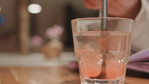 Close up view showing clear drinking glass being filled gradually with pink Stock Footage 345806632