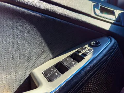 A close-up view shows the control panel of a car door featuring buttons for w Stock Photos