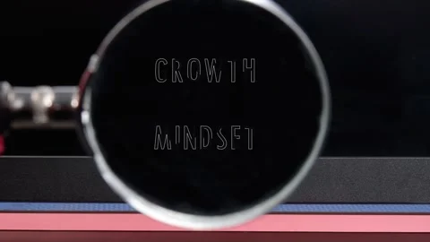 A close up view shows a hand holding a magnifying glass bringing the text Growth Stock Footage 332926498