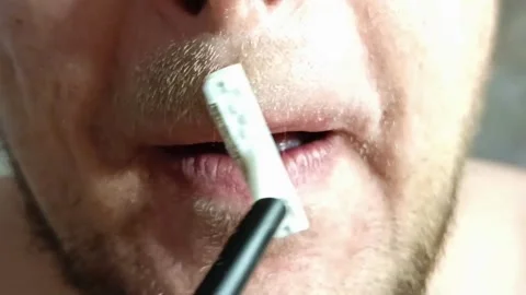 Close-up view shows a man shaving his lip area with a disposable razor Stock Footage 295496991