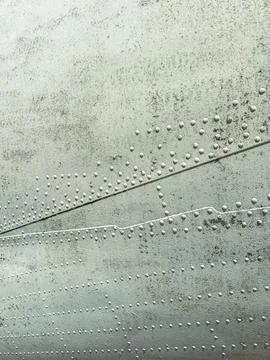 A close-up view shows a metal surface with rivets, patches, and lines. The te Stock Photos